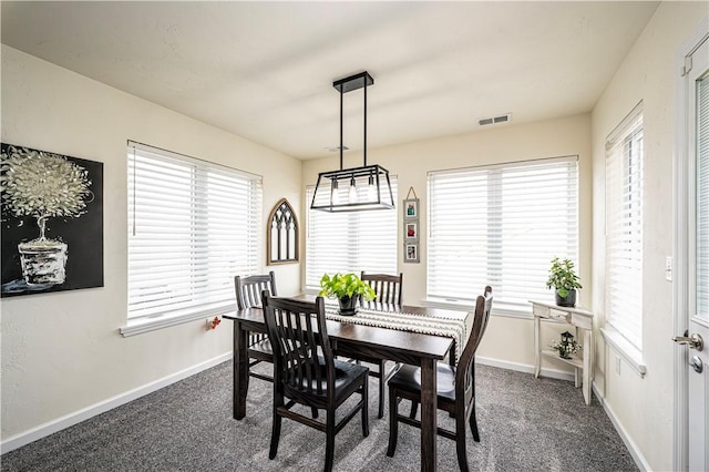 dining room with plenty of natural light and dark carpet