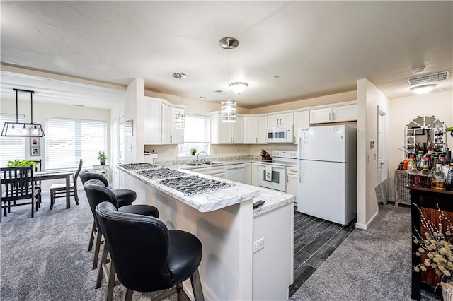 kitchen featuring pendant lighting, white cabinetry, white appliances, and kitchen peninsula