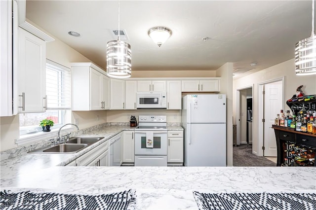 kitchen featuring white cabinets, decorative light fixtures, and white appliances