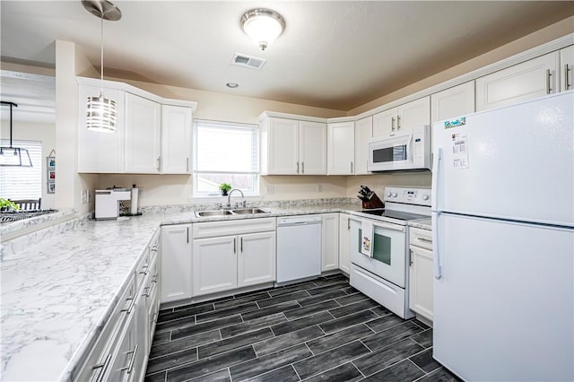 kitchen with sink, white cabinets, pendant lighting, and white appliances