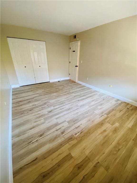 unfurnished bedroom featuring a closet and light wood-type flooring