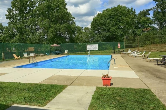 view of swimming pool featuring a yard and a patio