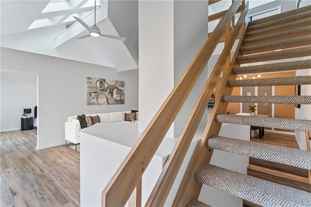 staircase featuring hardwood / wood-style floors and high vaulted ceiling