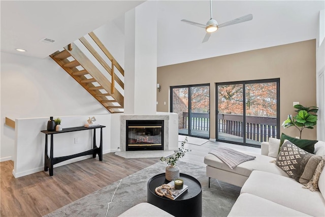 living room with a premium fireplace, ceiling fan, and light hardwood / wood-style floors