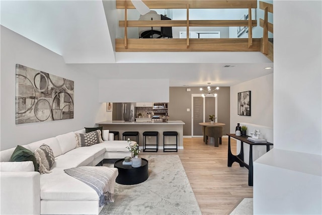 living room with light hardwood / wood-style floors and an inviting chandelier