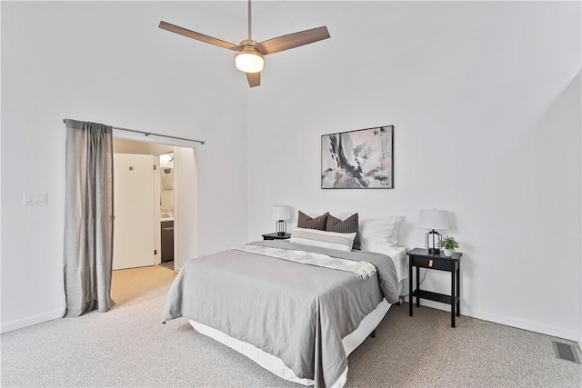 carpeted bedroom featuring connected bathroom and ceiling fan