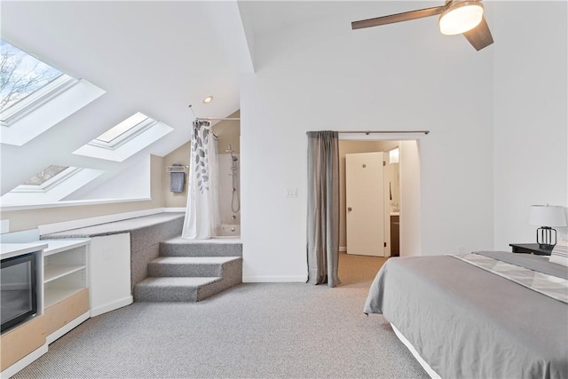 carpeted bedroom with lofted ceiling with skylight and ceiling fan