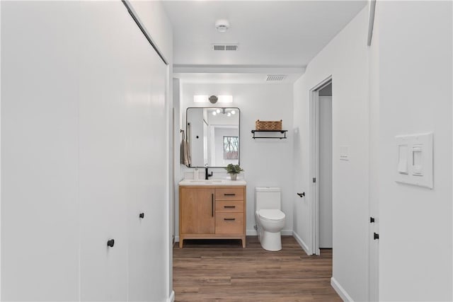 bathroom with vanity, wood-type flooring, and toilet