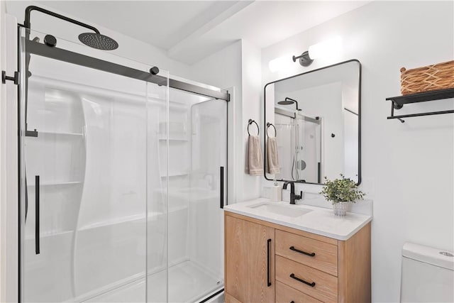 bathroom with vanity, a shower with shower door, and toilet