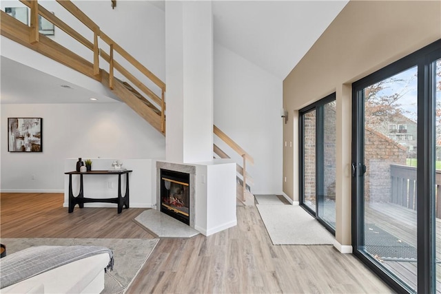 living room featuring light hardwood / wood-style floors and high vaulted ceiling