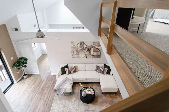 living room with ceiling fan, high vaulted ceiling, and light hardwood / wood-style floors