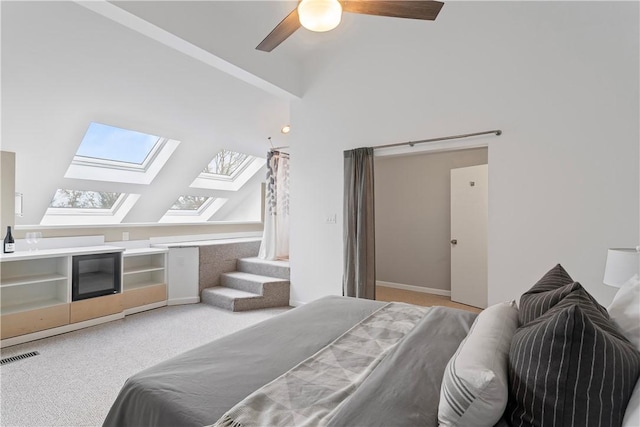 carpeted bedroom with ceiling fan and vaulted ceiling