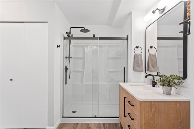 bathroom featuring a shower with door, vanity, and hardwood / wood-style flooring