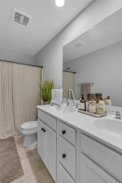 bathroom featuring toilet, vanity, and tile patterned floors