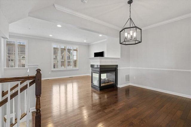 unfurnished living room with a multi sided fireplace, dark hardwood / wood-style floors, a wealth of natural light, and ornamental molding