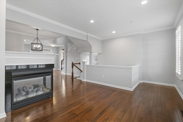 living room featuring dark hardwood / wood-style floors, crown molding, and an inviting chandelier