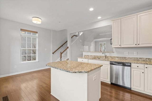 kitchen featuring a center island, dark wood-type flooring, white cabinets, sink, and stainless steel dishwasher