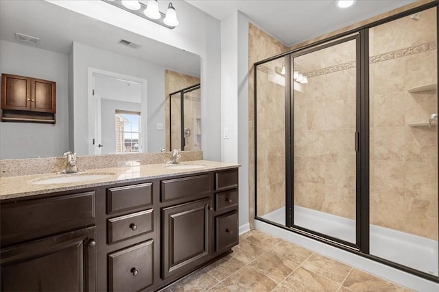 bathroom with tile patterned floors, vanity, and a shower with door