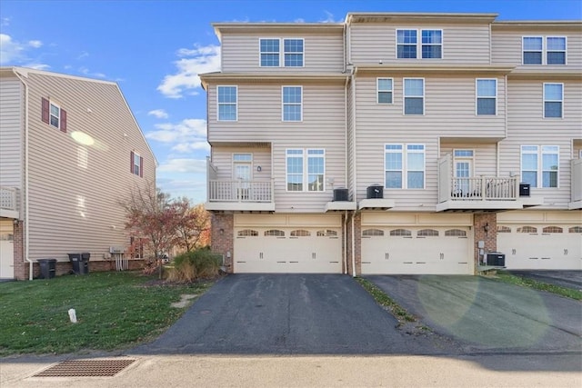 townhome / multi-family property featuring a garage and central AC unit