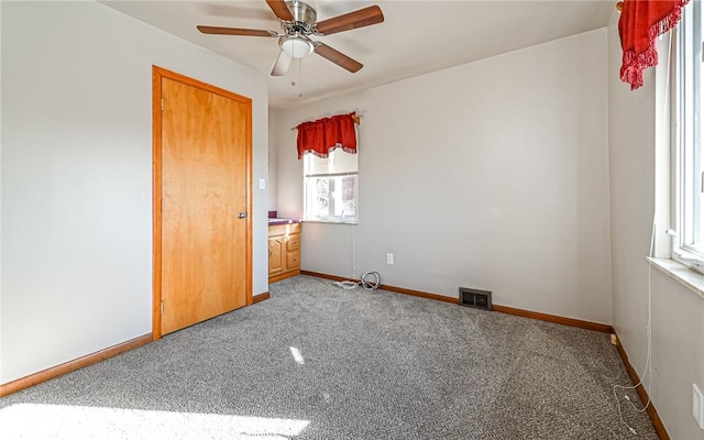 carpeted spare room with ceiling fan