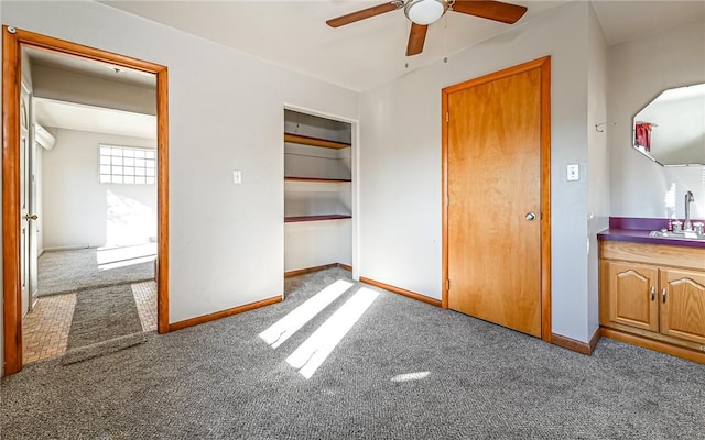 unfurnished bedroom featuring carpet floors, a closet, ceiling fan, and sink