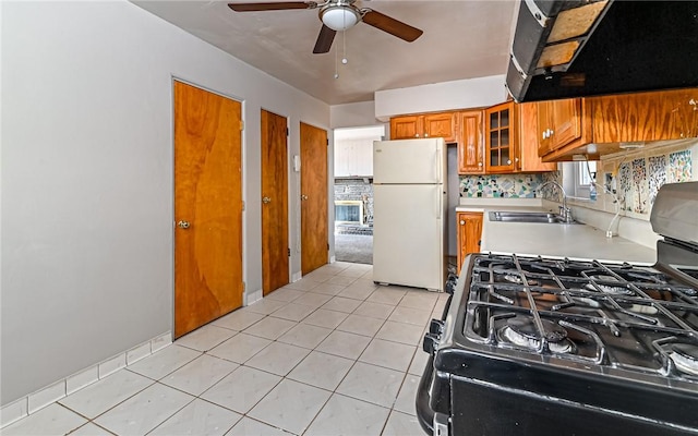 kitchen with sink, white refrigerator, range with gas stovetop, decorative backsplash, and exhaust hood