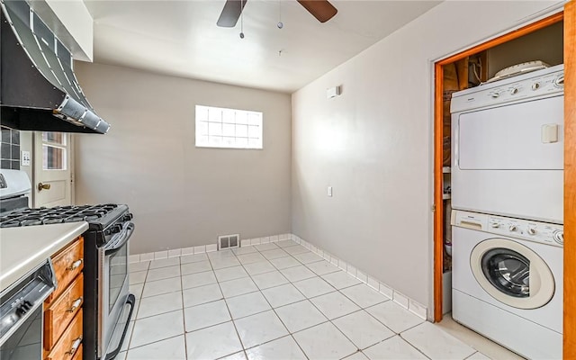 laundry area featuring light tile patterned floors, ceiling fan, and stacked washer and clothes dryer