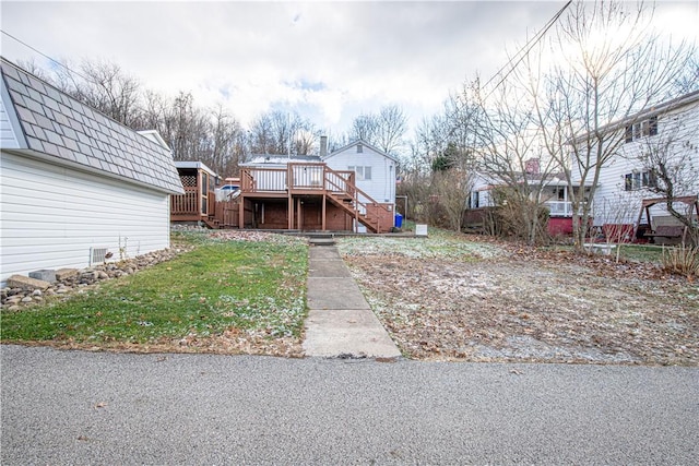 view of front of property with a front yard and a wooden deck