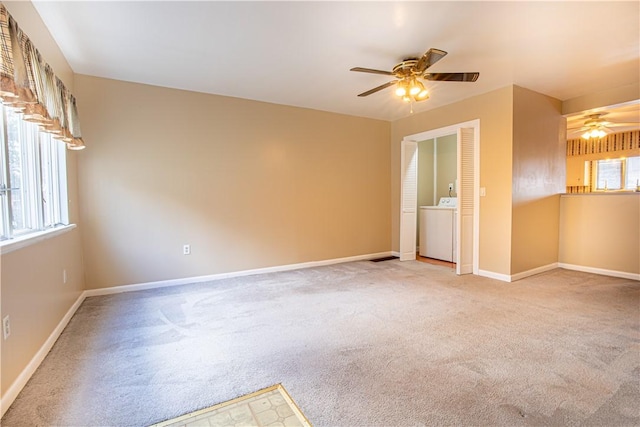 carpeted spare room featuring ceiling fan and washer / dryer