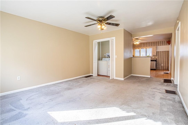 unfurnished living room with light carpet, washer and clothes dryer, and ceiling fan