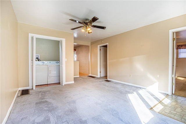 unfurnished bedroom with ensuite bath, ceiling fan, washer and clothes dryer, and light carpet