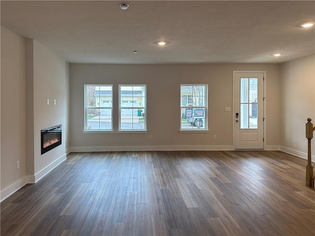 unfurnished living room with dark wood-type flooring