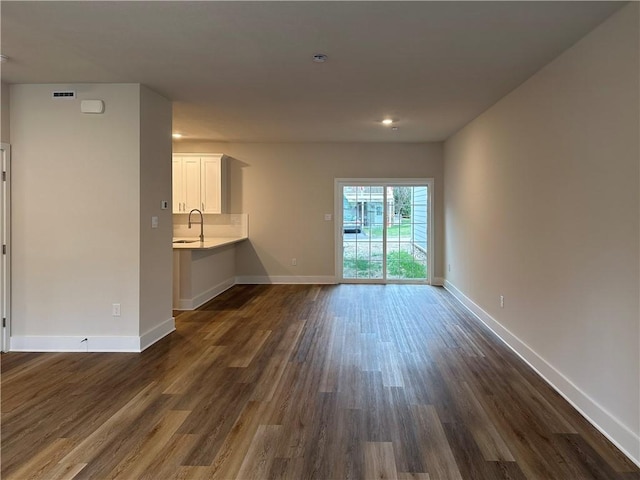 unfurnished living room with sink and dark hardwood / wood-style floors