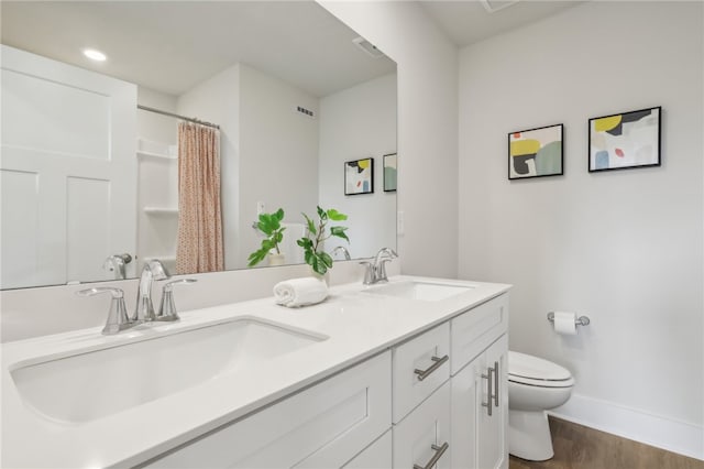 bathroom with vanity, hardwood / wood-style flooring, and toilet