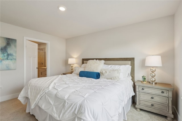 bedroom featuring light carpet and ensuite bathroom