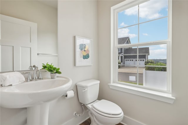 bathroom with plenty of natural light, toilet, and sink