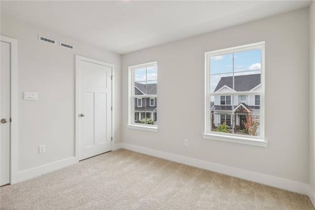 carpeted spare room with plenty of natural light