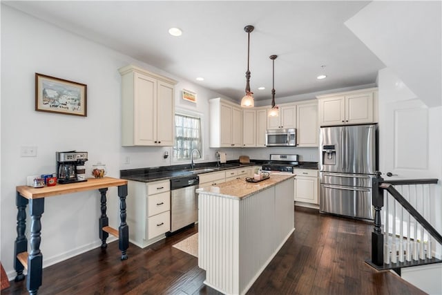 kitchen featuring dark wood-type flooring, hanging light fixtures, a kitchen island, and stainless steel appliances