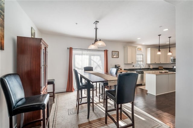 dining space with dark hardwood / wood-style flooring, sink, and a wealth of natural light