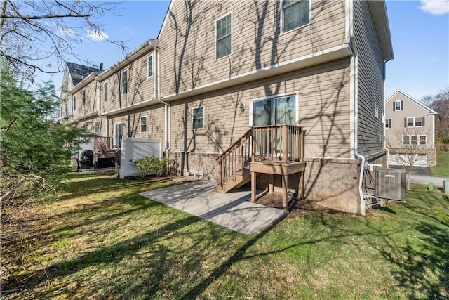 back of property with a lawn, a patio area, and central AC