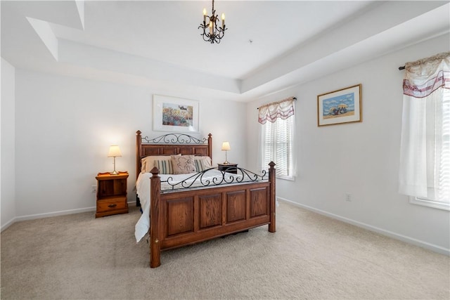 carpeted bedroom with a notable chandelier and a raised ceiling