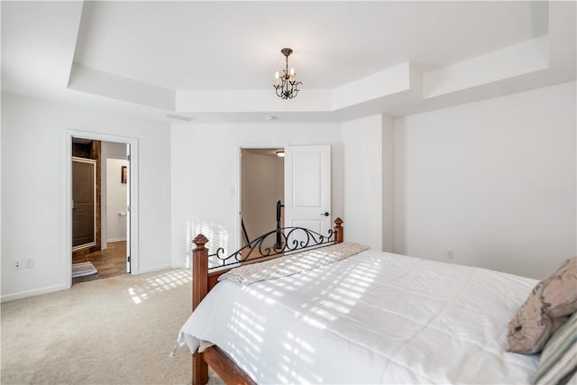 bedroom featuring carpet flooring, an inviting chandelier, and a raised ceiling