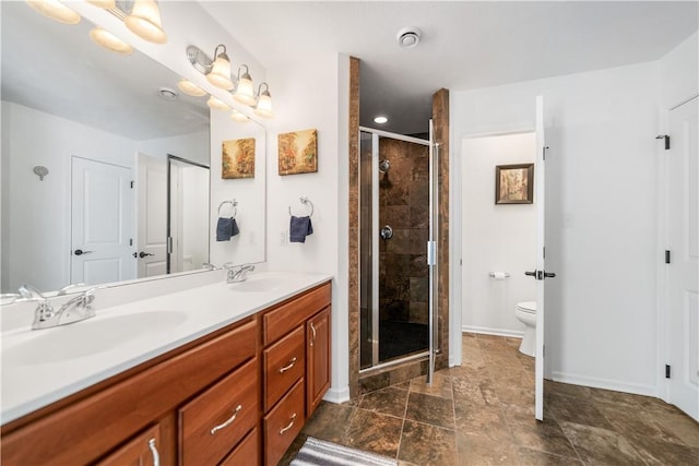 bathroom with vanity, toilet, and a shower with door