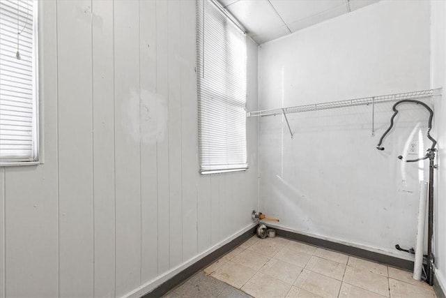 clothes washing area featuring wood walls