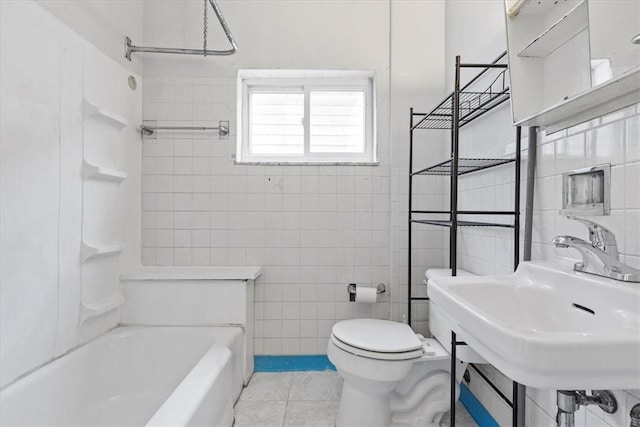 full bathroom featuring tile patterned floors, tiled shower / bath combo, sink, tile walls, and toilet