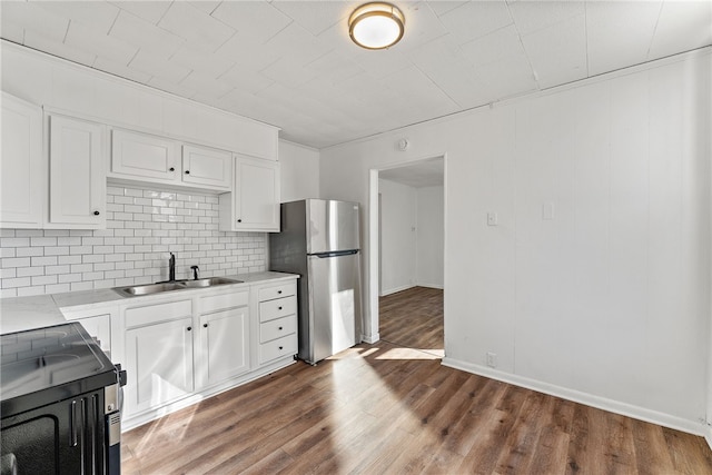 kitchen featuring sink, range, dark wood-type flooring, and stainless steel refrigerator