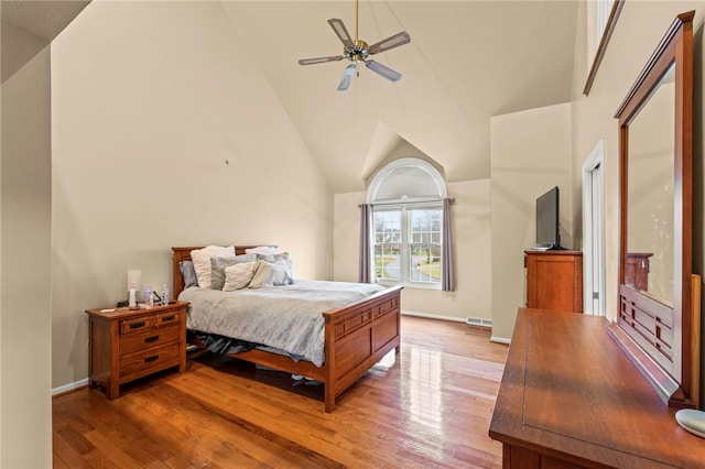 bedroom featuring ceiling fan, hardwood / wood-style floors, and high vaulted ceiling