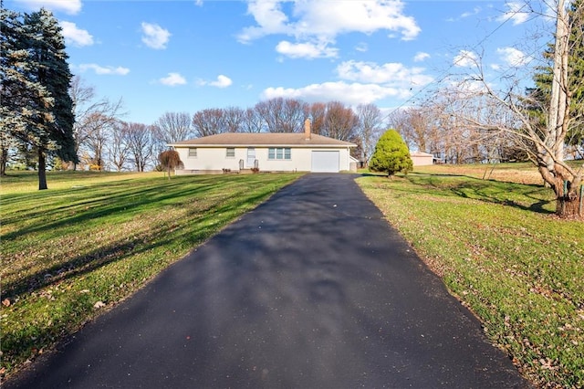 single story home with a garage and a front lawn