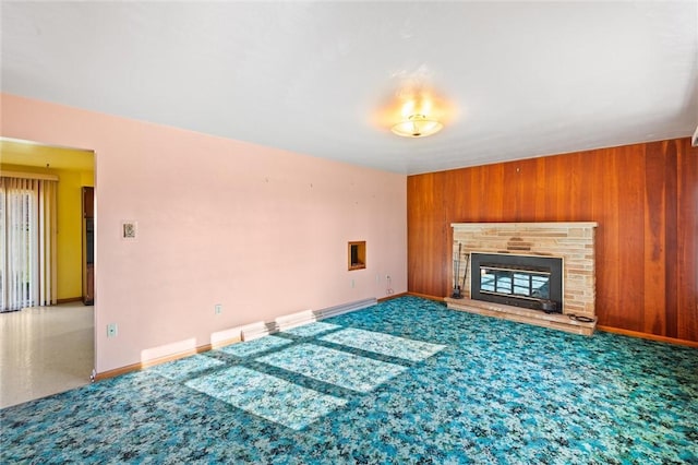 unfurnished living room with wood walls and a fireplace