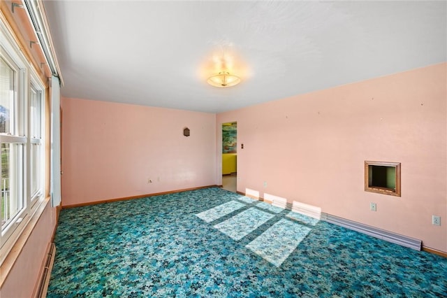 empty room featuring carpet and baseboard heating